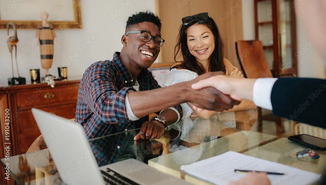 Two WFDSA members shaking hands across a desk